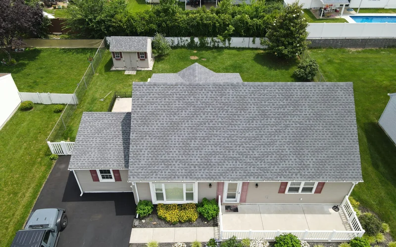 Aerial view of a suburban house with a grey asphalt shingle roof (stock photo)